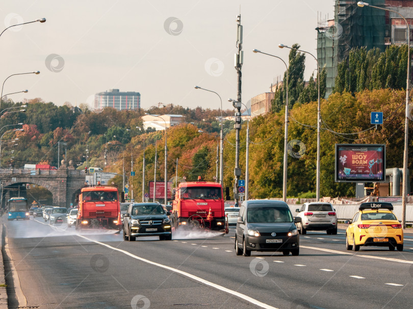 Скачать Поливальные машины работают на городской улице. Москва фотосток Ozero