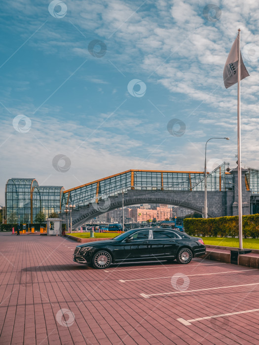 Скачать Черный современный лимузин Mercedes-Maybach стоит на парковке под осенним солнцем на улице. фотосток Ozero