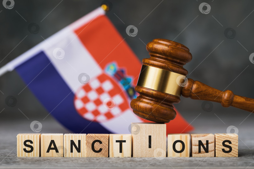 Скачать Судейский молоток, деревянные кубики с текстом на фоне хорватского флага, концепция на тему санкций в Хорватии фотосток Ozero