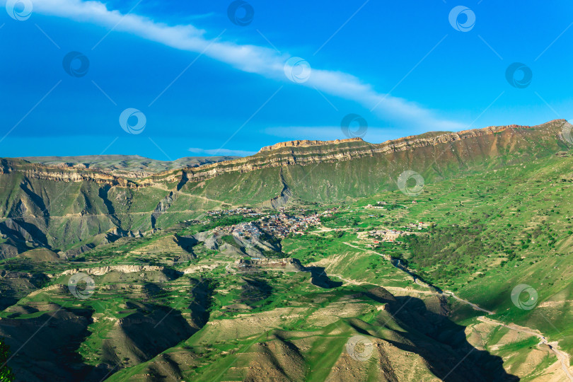 Скачать горный пейзаж с деревней на склоне под огромным скалистым хребтом, Чох в Дагестане фотосток Ozero
