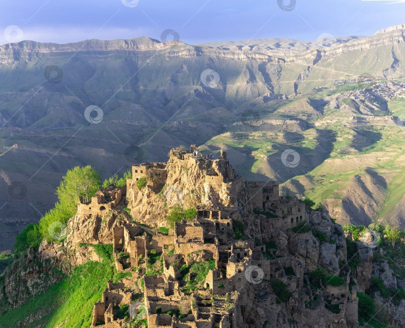 Скачать вид на необитаемую деревню Гамсутль на вершине горы в Дагестане, вдали видна населенная деревня Чох фотосток Ozero