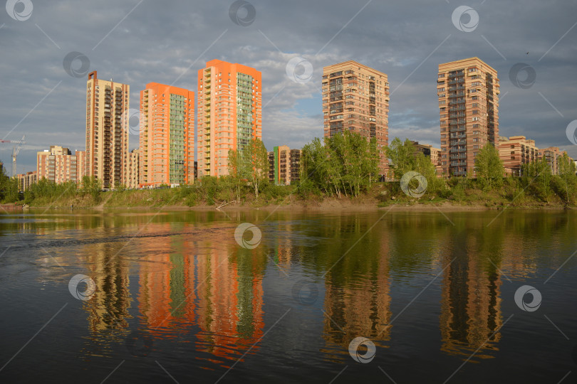 Скачать Современные яркие городские здания на берегу реки отражаются в воде фотосток Ozero