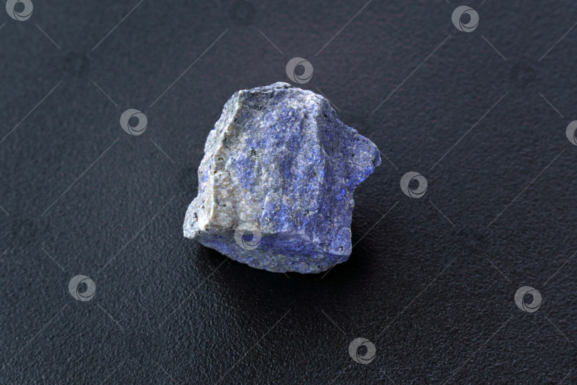 Скачать Необработанный минерал дюмортьерит имеет голубоватый цвет на черном фоне. фотосток Ozero