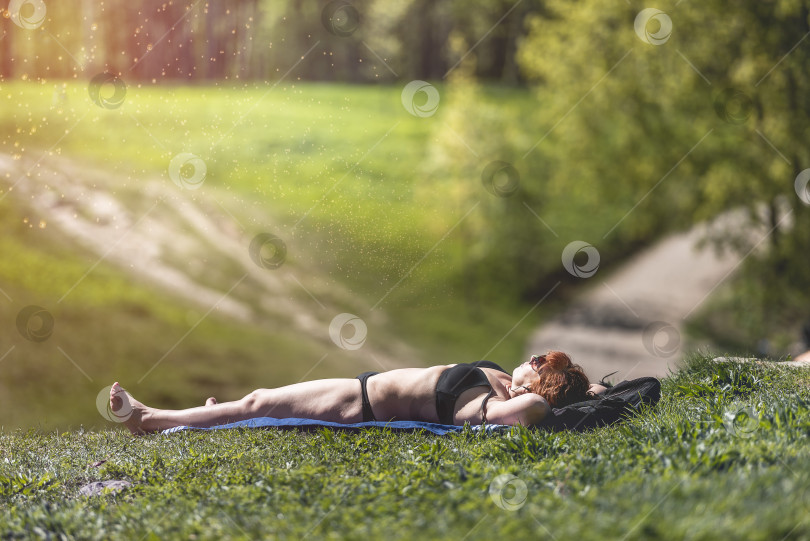 Скачать Женщина загорает на поляне в парке. Россия, Гатчина, май 2022 года фотосток Ozero