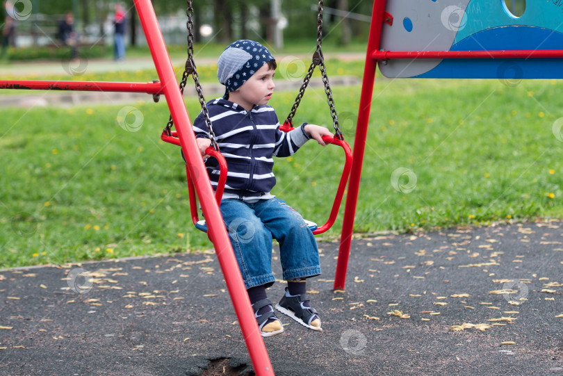 Скачать Маленький мальчик катается на качелях фотосток Ozero