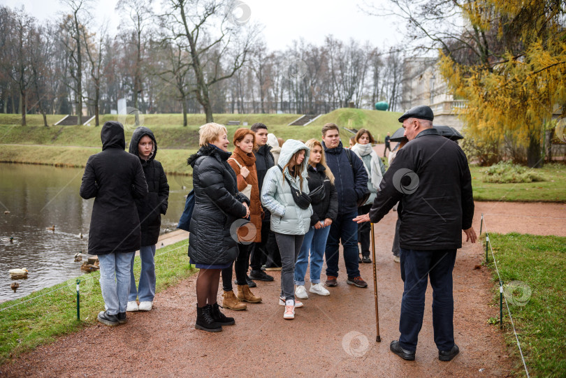 Скачать Россия, Гатчина, 29 октября 2022 года: Группа туристов с гидом в дворцовом парке фотосток Ozero