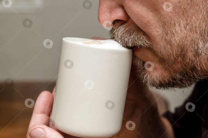 Скачать мужчина пьет кофе капучино крупным планом, усы в пене фотосток Ozero