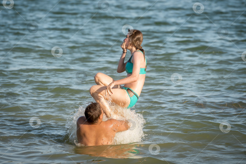 Скачать Парни на озере бросают девушку в воду фотосток Ozero