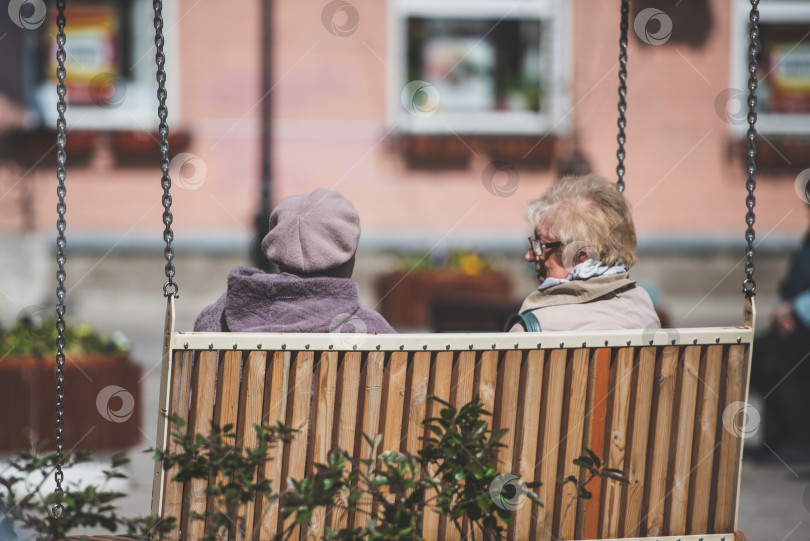 Скачать Пожилые женщины на качелях отдыхают в городе. Россия, Гатчина, май 2022 года. фотосток Ozero