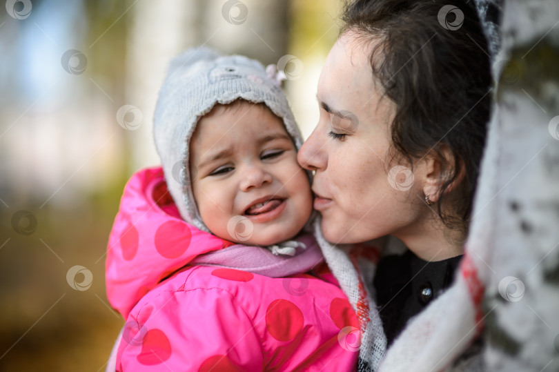 Скачать счастливая мать целует маленькую дочь в осеннем парке - крупный план фотосток Ozero