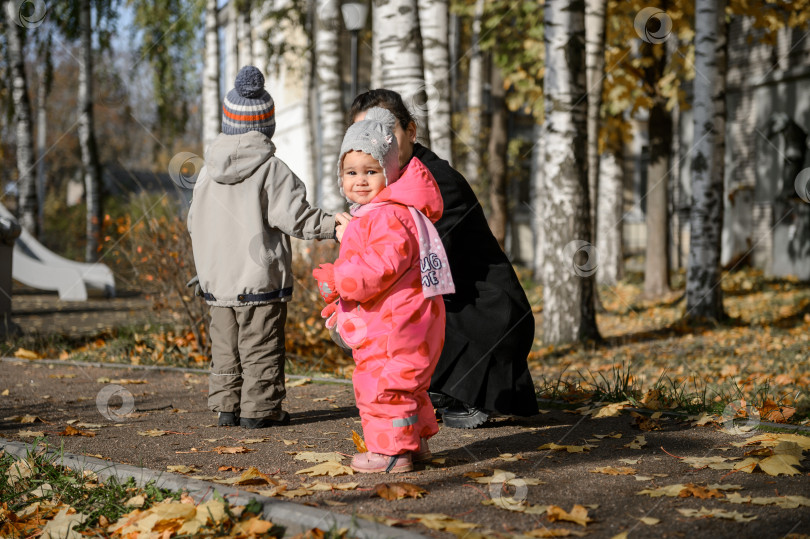 Скачать Молодая мать с маленькими дочерью и сыном на прогулке фотосток Ozero