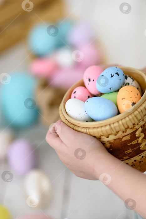 Скачать Пасхальные яйца в корзинке держат детские руки. Крупный план пасхальных яиц. фотосток Ozero