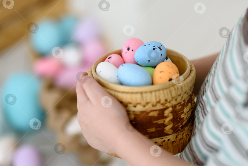 Скачать Пасхальные яйца в корзинке держат детские руки. Крупный план пасхальных яиц. фотосток Ozero