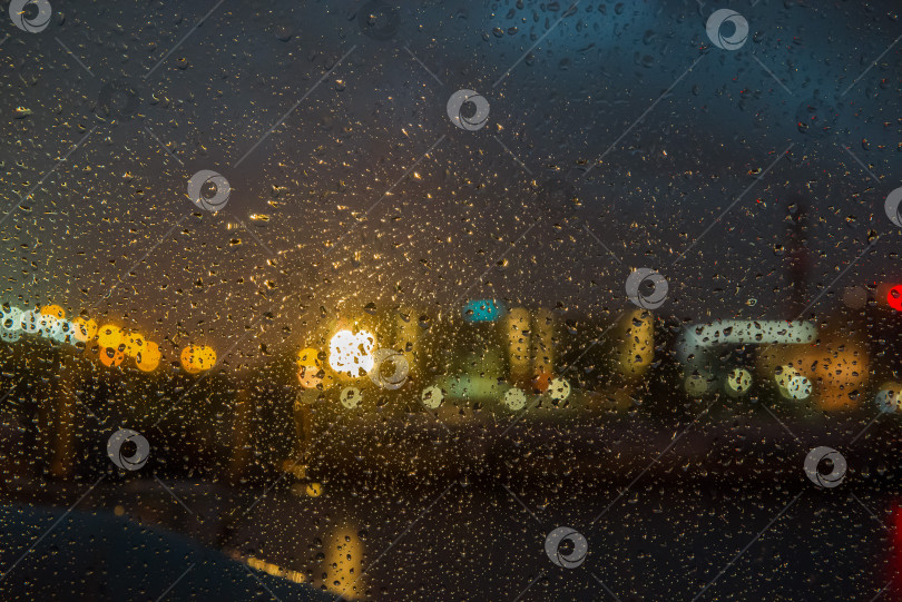 Скачать Вид сквозь мокрое стекло на ночные огни набережной фотосток Ozero