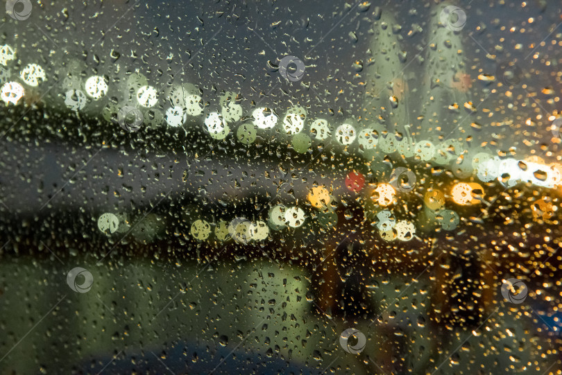 Скачать Вид сквозь мокрое стекло на ночные огни набережной фотосток Ozero