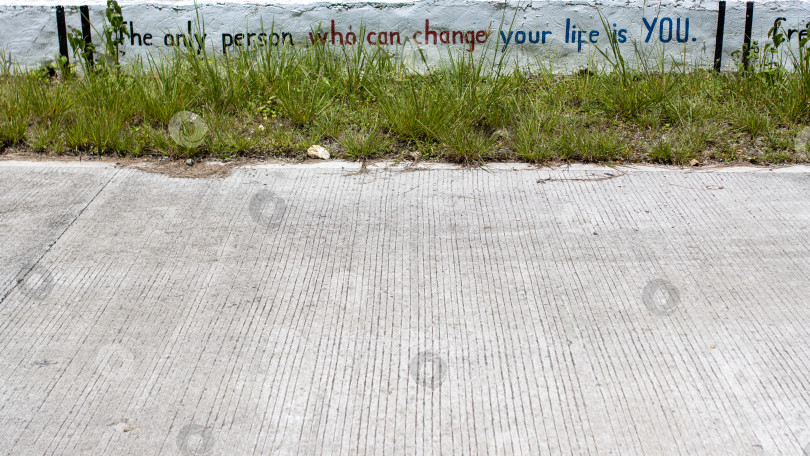 Скачать бетон с мотивирующей надписью: "единственный человек, который может изменить твою жизнь", - это бетонное шоссе с мотивирующей надписью: "единственный человек, который может изменить твою жизнь, - это ты сам". фотосток Ozero
