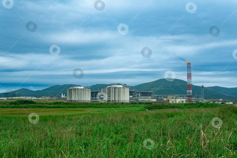 Скачать завод по производству сжиженного природного газа в природной зоне на фоне гор фотосток Ozero