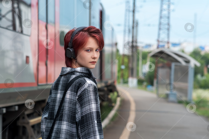 Скачать девочка-подросток в наушниках на станции пригородного поезда фотосток Ozero