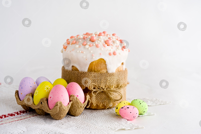 Скачать Пасхальный кулич и крашеные яйца на белом льняном фоне фотосток Ozero