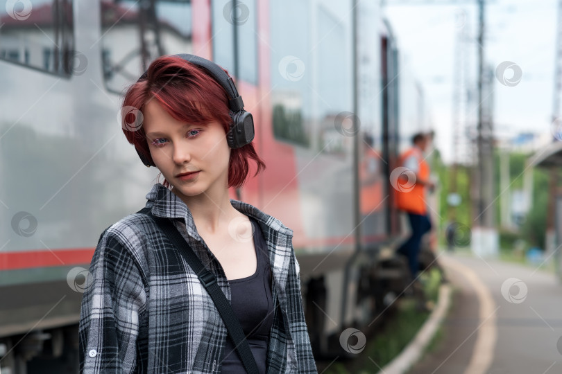 Скачать девочка-подросток в наушниках на станции пригородного поезда фотосток Ozero