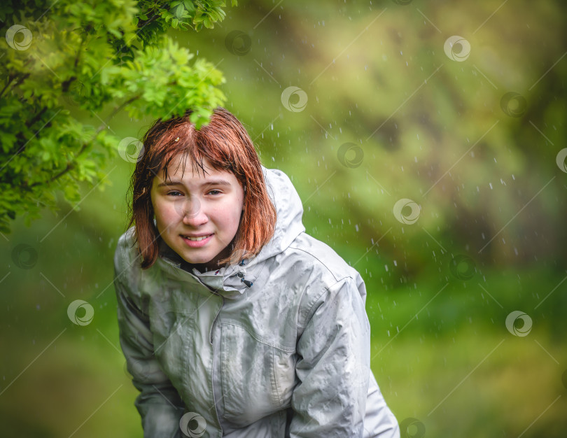 Скачать молодая девушка прячется от дождя под кустом фотосток Ozero