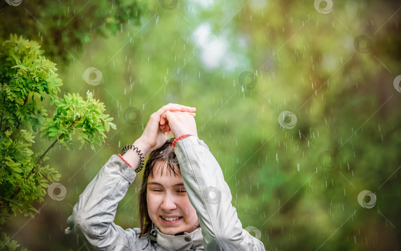 Скачать молодая девушка прикрывает голову руками от дождя фотосток Ozero