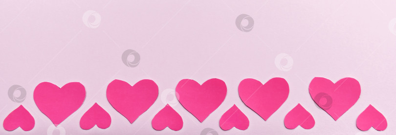 Скачать Красные сердечки на романтическом розовом фоне. фотосток Ozero