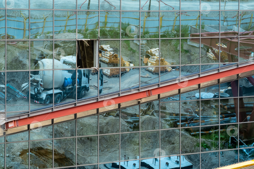 Скачать промышленный фон - зеркальная стена недостроенного здания, в которой отражается строительная площадка фотосток Ozero