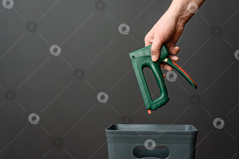 Скачать Строительный степлер выбрасывается в мусорное ведро для утилизации фотосток Ozero