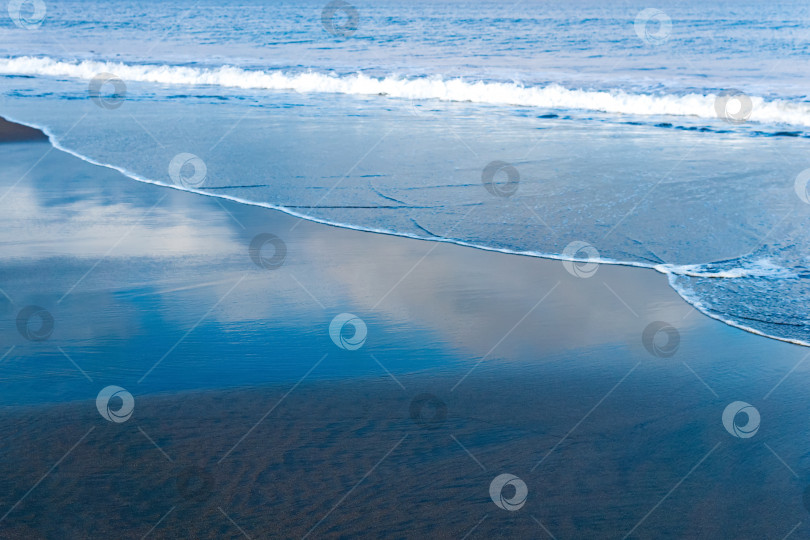 Скачать океанский пляж с черным вулканическим песком, небо отражается в откатывающейся волне прибоя фотосток Ozero