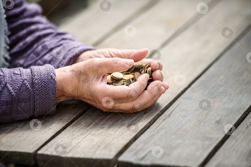 Скачать руки старухи держат горсть монет на деревянном столе фотосток Ozero