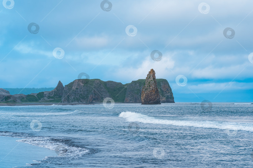 Скачать морской пейзаж Кунашира, океанский берег с огромной вертикальной скалой в воде фотосток Ozero