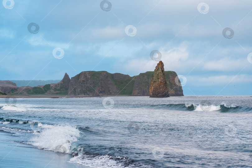 Скачать морской пейзаж Кунашира, океанский берег с огромной вертикальной скалой в воде фотосток Ozero