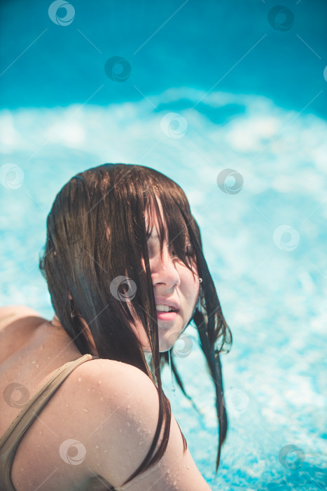 Скачать Молодая девушка смеется под плеск воды в бассейне фотосток Ozero