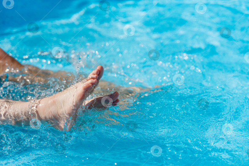 Скачать Женские ноги в воде в бассейне, крупным планом. фотосток Ozero