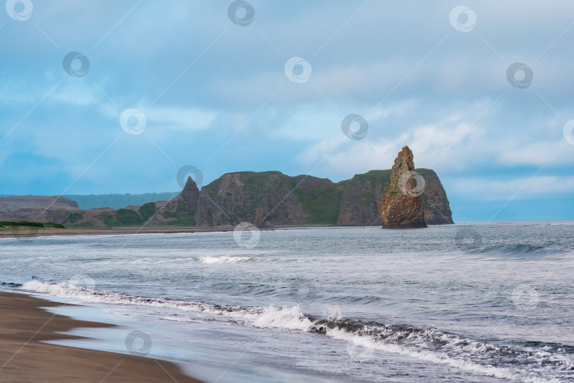 Скачать морской пейзаж Кунашира, океанский берег с огромной вертикальной скалой в воде фотосток Ozero