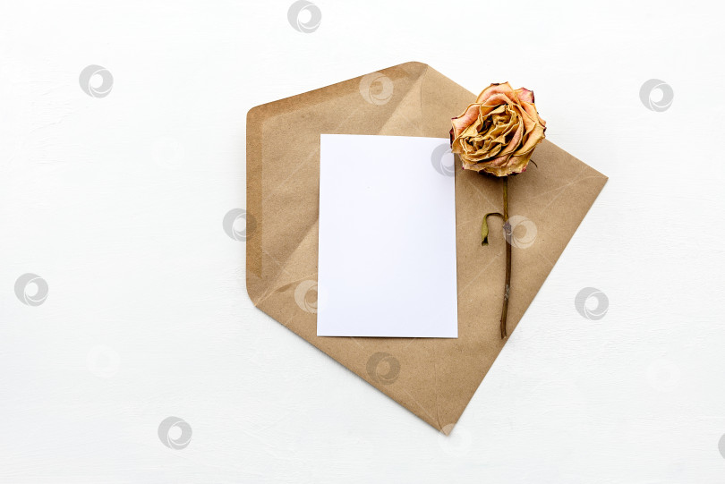 Скачать Вид сверху на конверт из крафт-бумаги и белую открытку. Фон канцелярской моды. фотосток Ozero