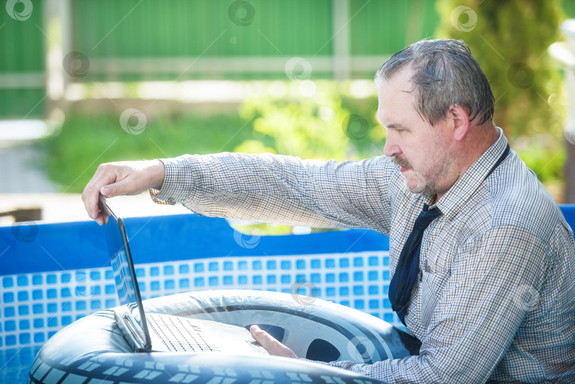 Скачать Деловой человек с ноутбуком работает в бассейне фотосток Ozero