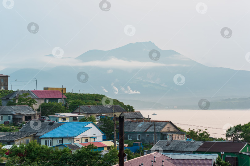 Скачать пейзаж города Южно-Курильск на острове Кунашир с видом на морской залив и вулкан Менделеева вдалеке фотосток Ozero