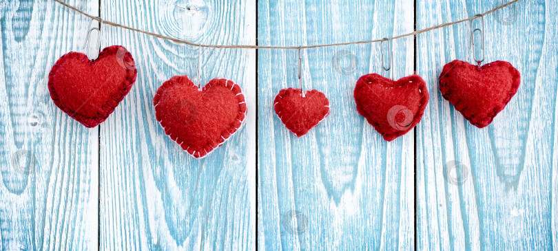 Скачать Сердечки, висящие на деревянном фоне. День святого Валентина. Фон. фотосток Ozero