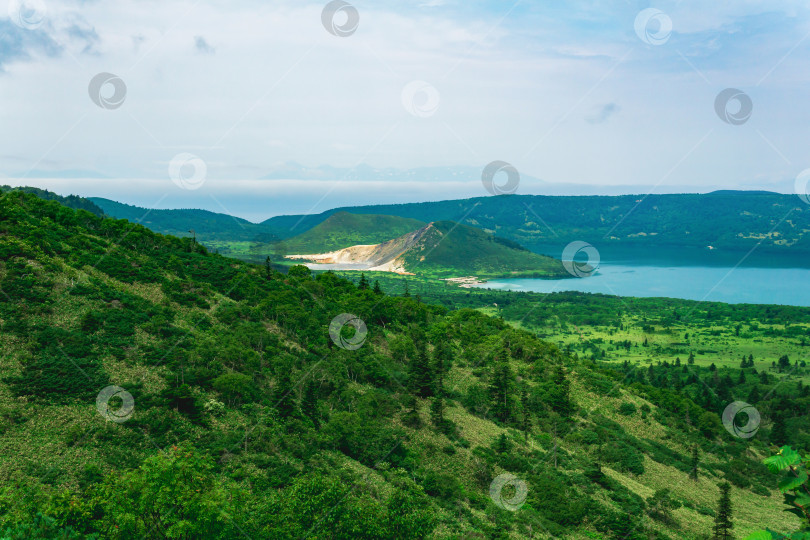 Скачать пейзаж острова Кунашир, геотермальные озера среди лавовых куполов в центре кальдеры вулкана Головнин; остров Хоккайдо виден вдалеке в море фотосток Ozero