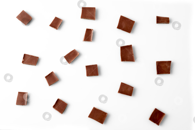 Скачать Кусочки шоколада на белом фоне, вид сверху фотосток Ozero