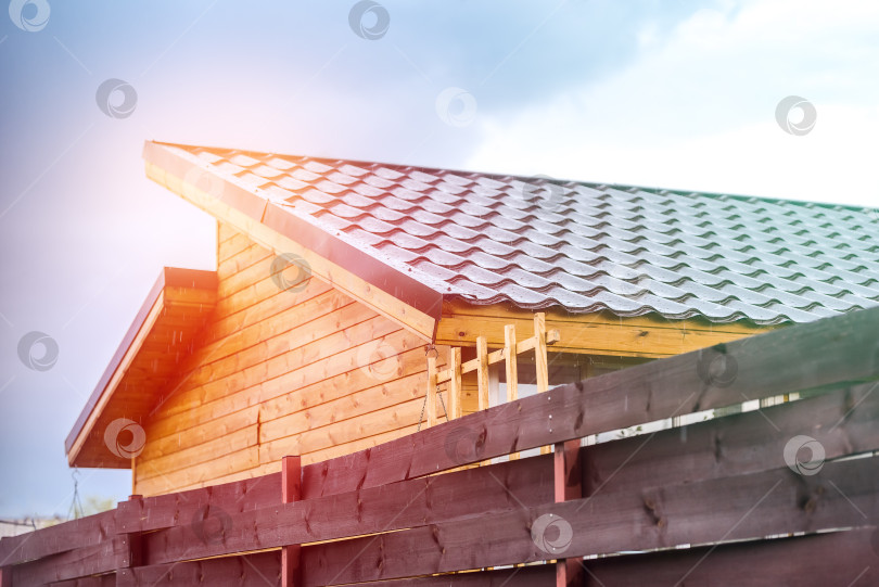 Скачать Черепичная крыша деревенского дома освещается солнцем после дождя фотосток Ozero