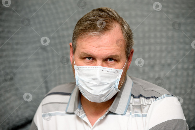 Скачать человек в медицинской маске, карантин и самоизоляция - усталое выражение на его лице. фотосток Ozero