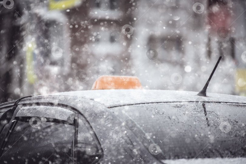 Скачать Крыша автомобиля такси в снегу крупным планом в зимний день, во время снегопада фотосток Ozero