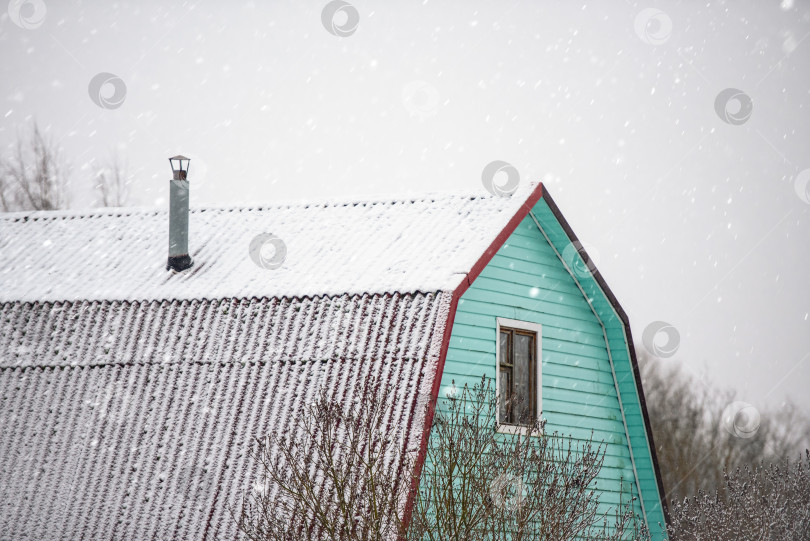 Скачать крыша деревенского дома зимой во время снегопада фотосток Ozero