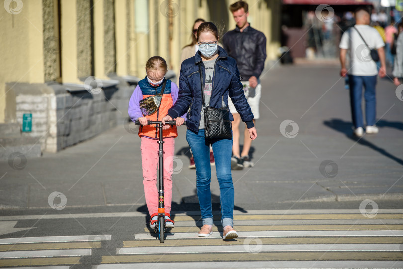 Скачать Россия, Санкт-Петербург, 30 мая 2020 года: Люди в городе на тротуаре. катание на скутерах по городу. Пешеходный переход. фотосток Ozero