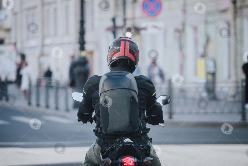 Скачать Россия, Санкт-Петербург, 26 июня 2020 года: вид сзади на мотоциклиста, едущего по городской улице фотосток Ozero
