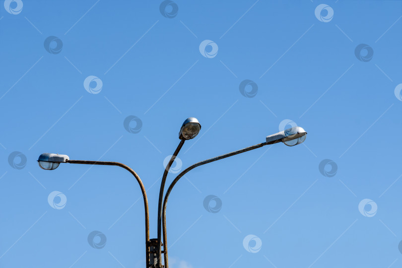 Скачать Уличные фонари на столбе на фоне голубого неба фотосток Ozero