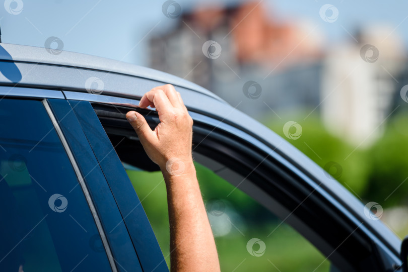 Скачать Мужская рука из окна автомобиля в пробке в жаркую погоду. фотосток Ozero